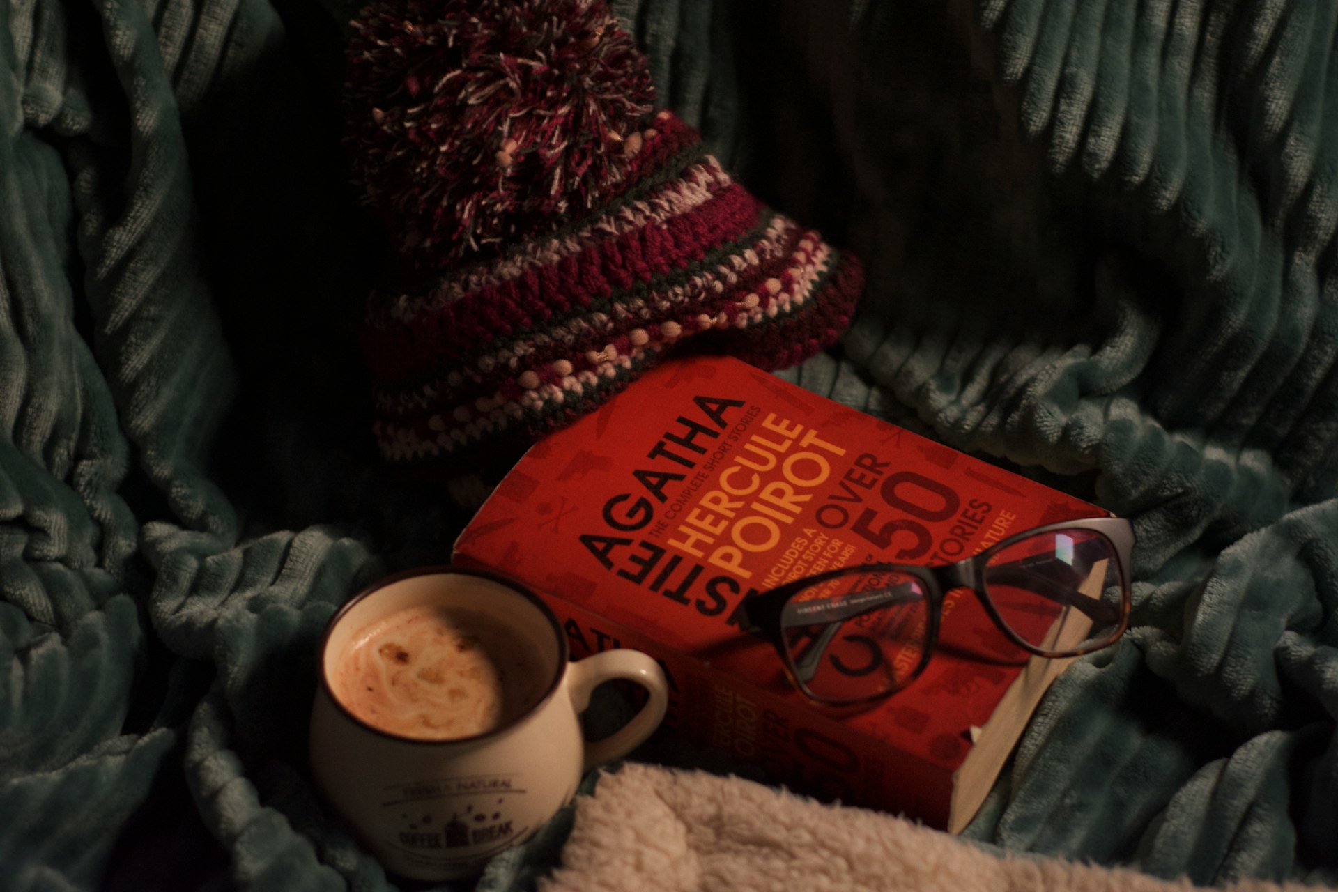 A cup of coffee and a book on a blanket